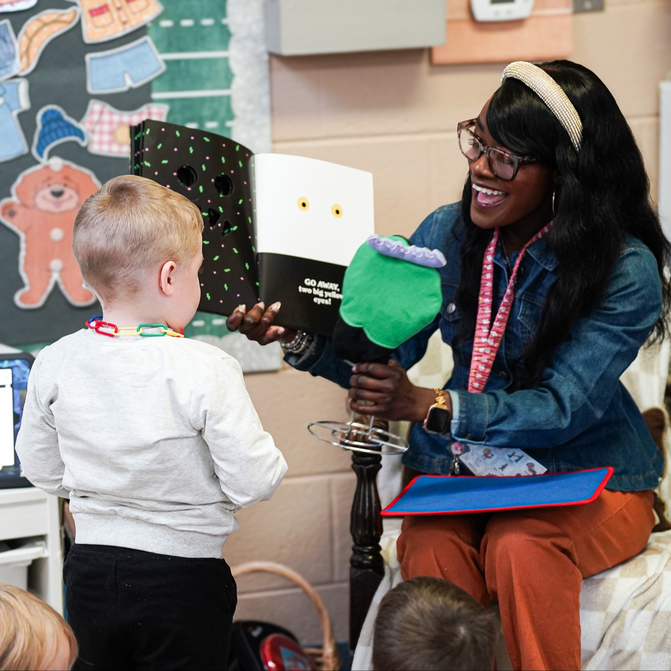 a teacher reads a book to a child