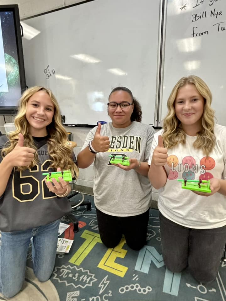 DMS students with thumbs up poses in a classroom setting