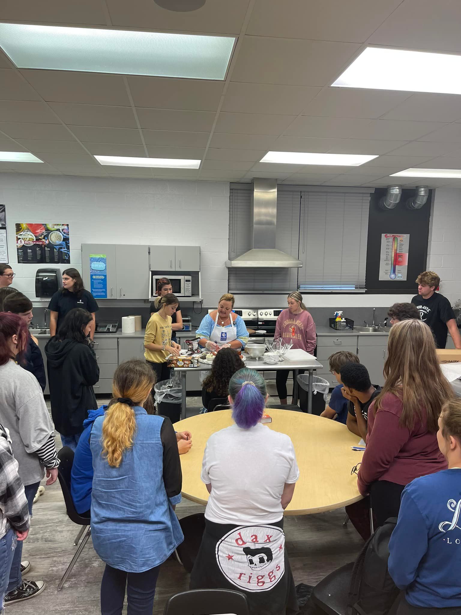 People gathered around table in cooking class.