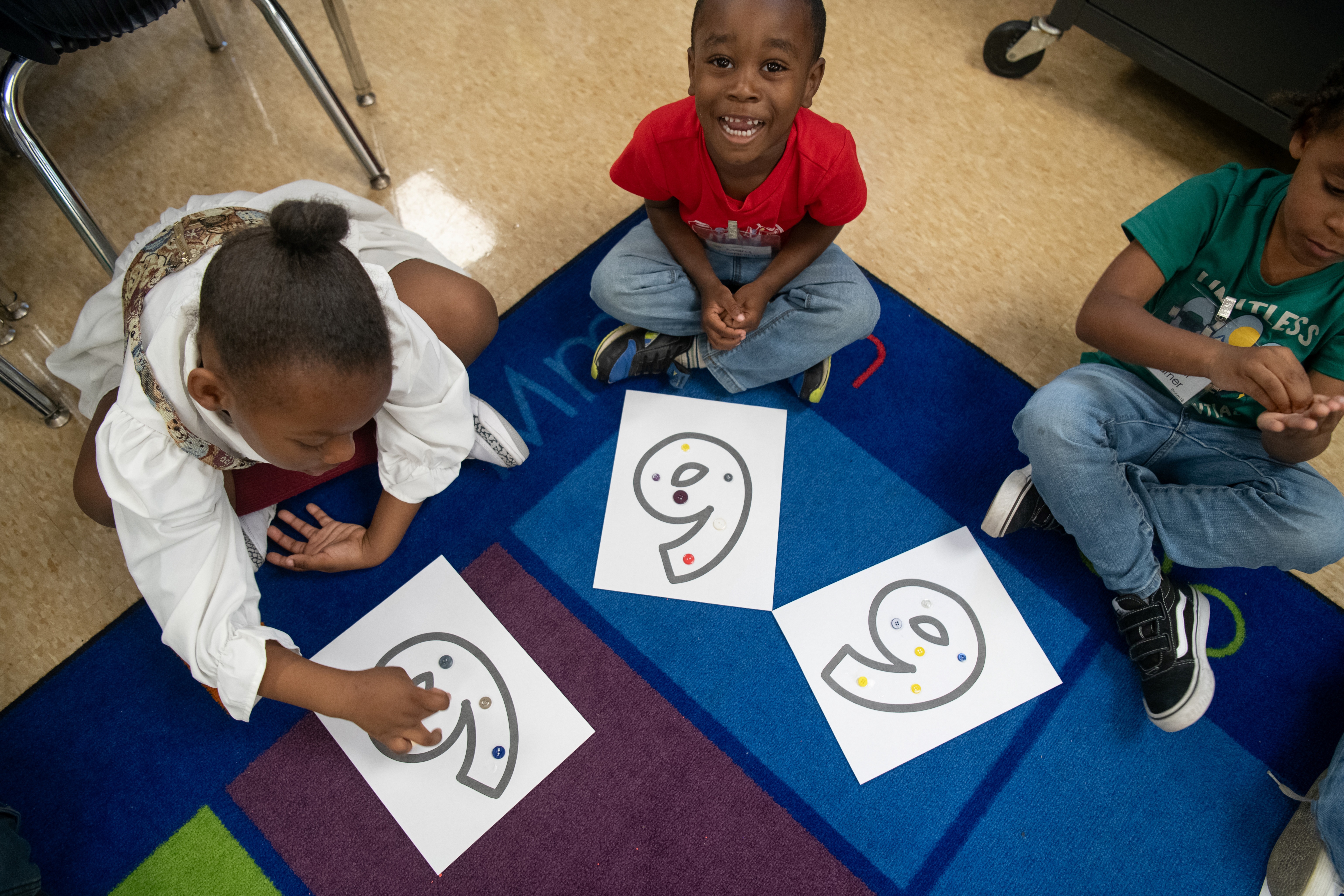 Three Kindergarten students on the carpet