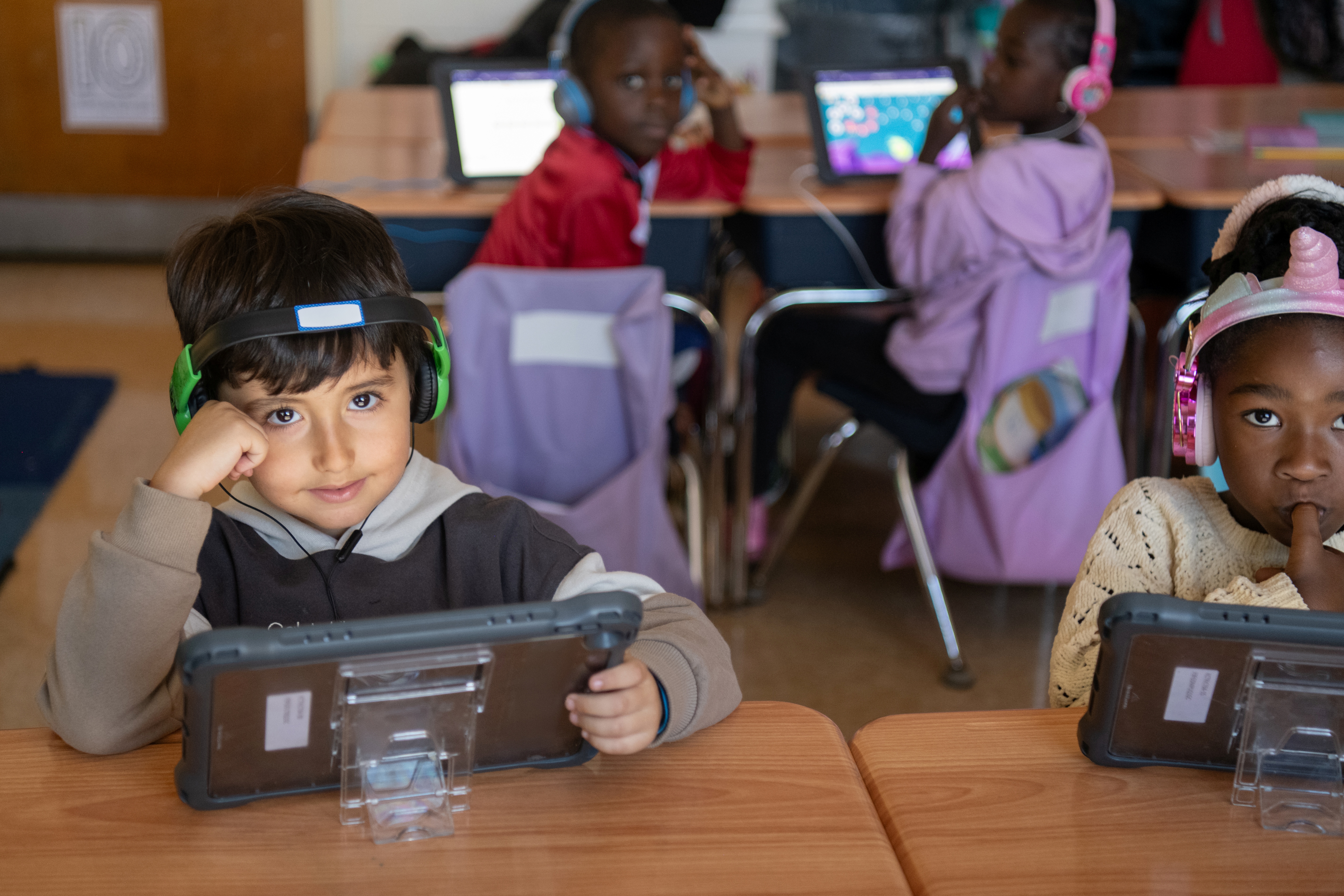 K students wearing headsets and looking at camera