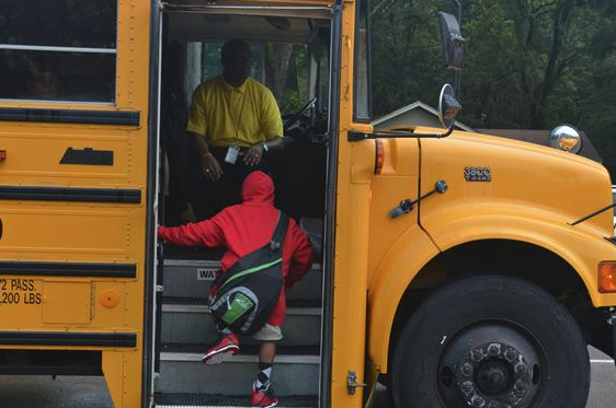 school bus driver and a kid getting in the bus