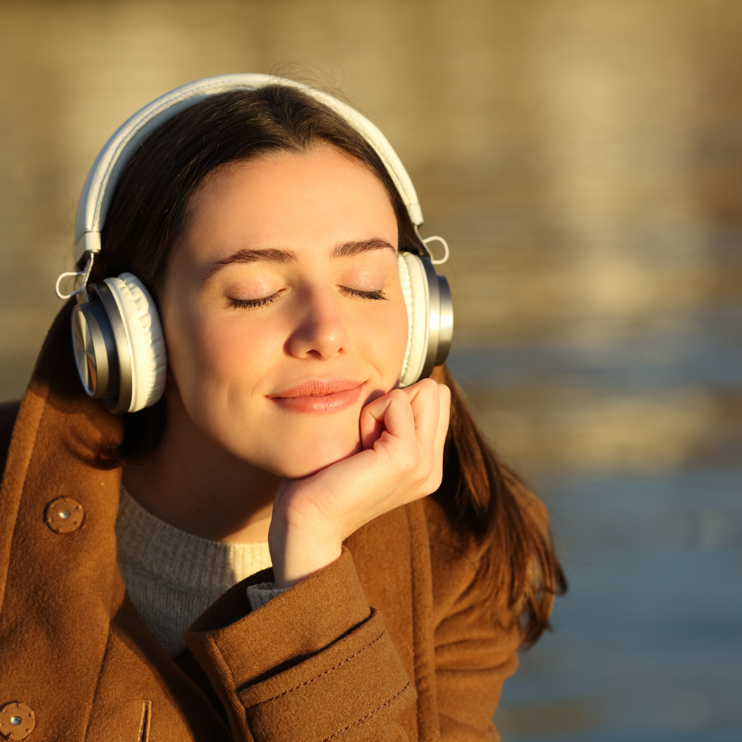 Girl listening to music by water