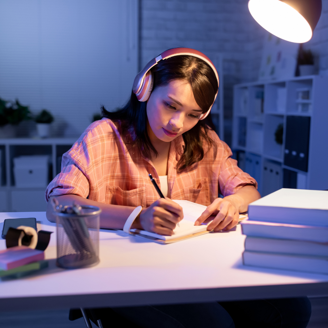 girl studying while listening to music with headphones