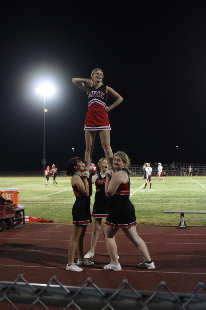 Cheerleaders in a game doing a pyramid