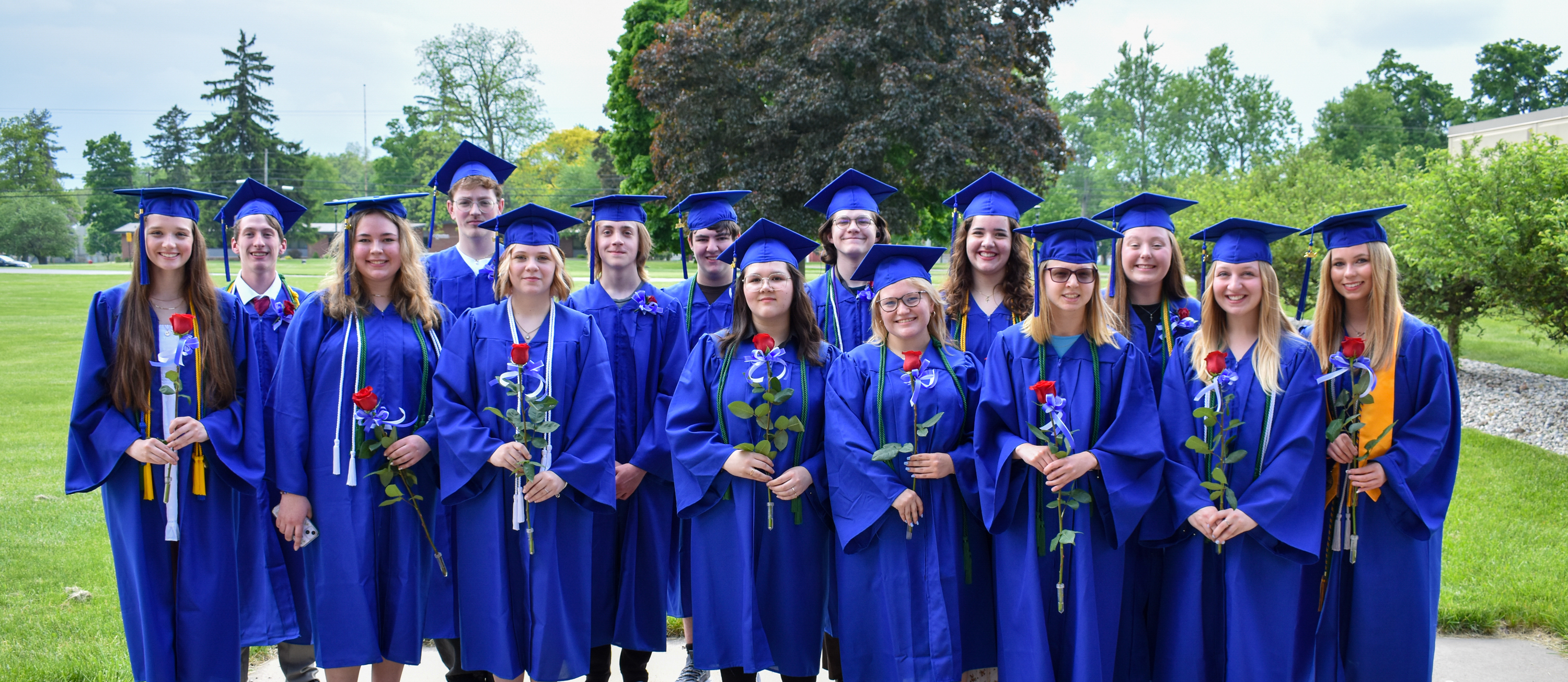 Academy graduates in blue caps and gowns