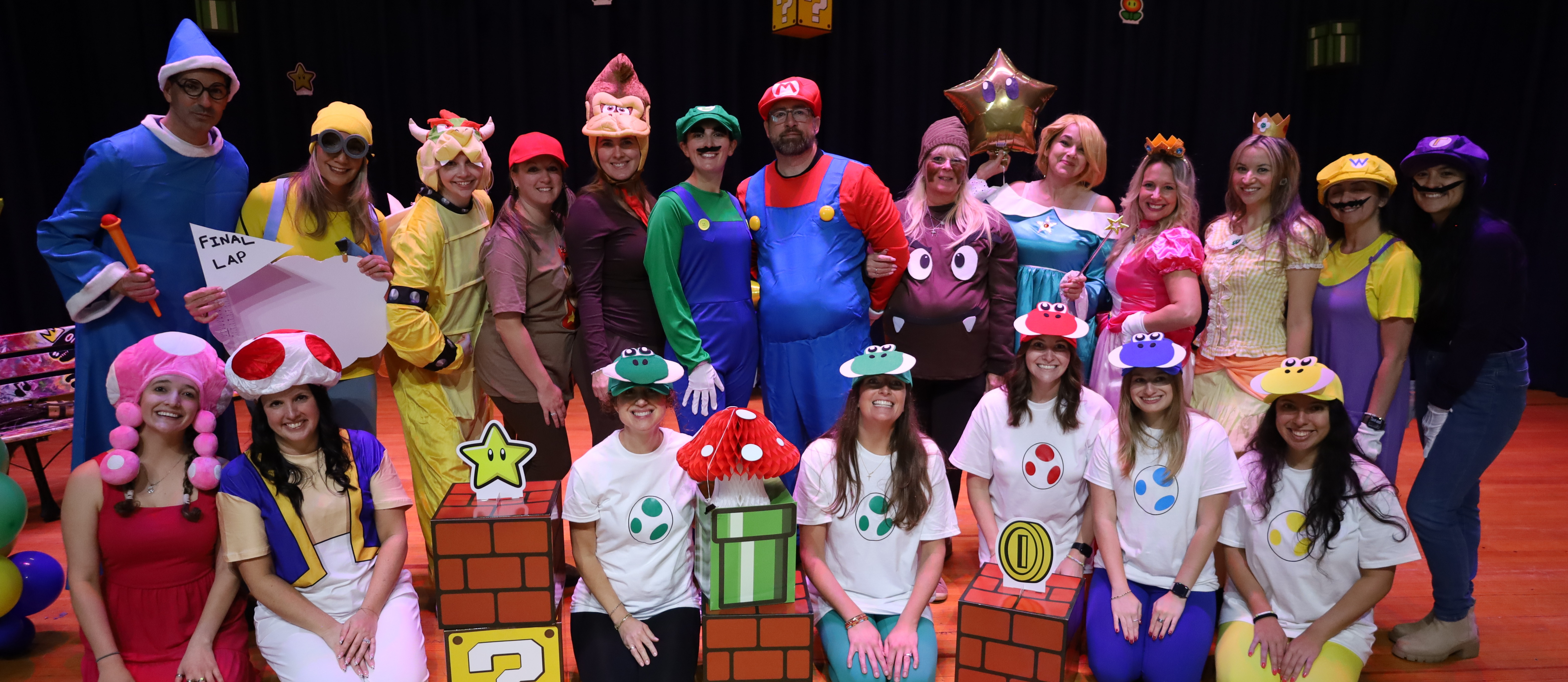Group photo of teachers and students dressed as Mario Bros characters.