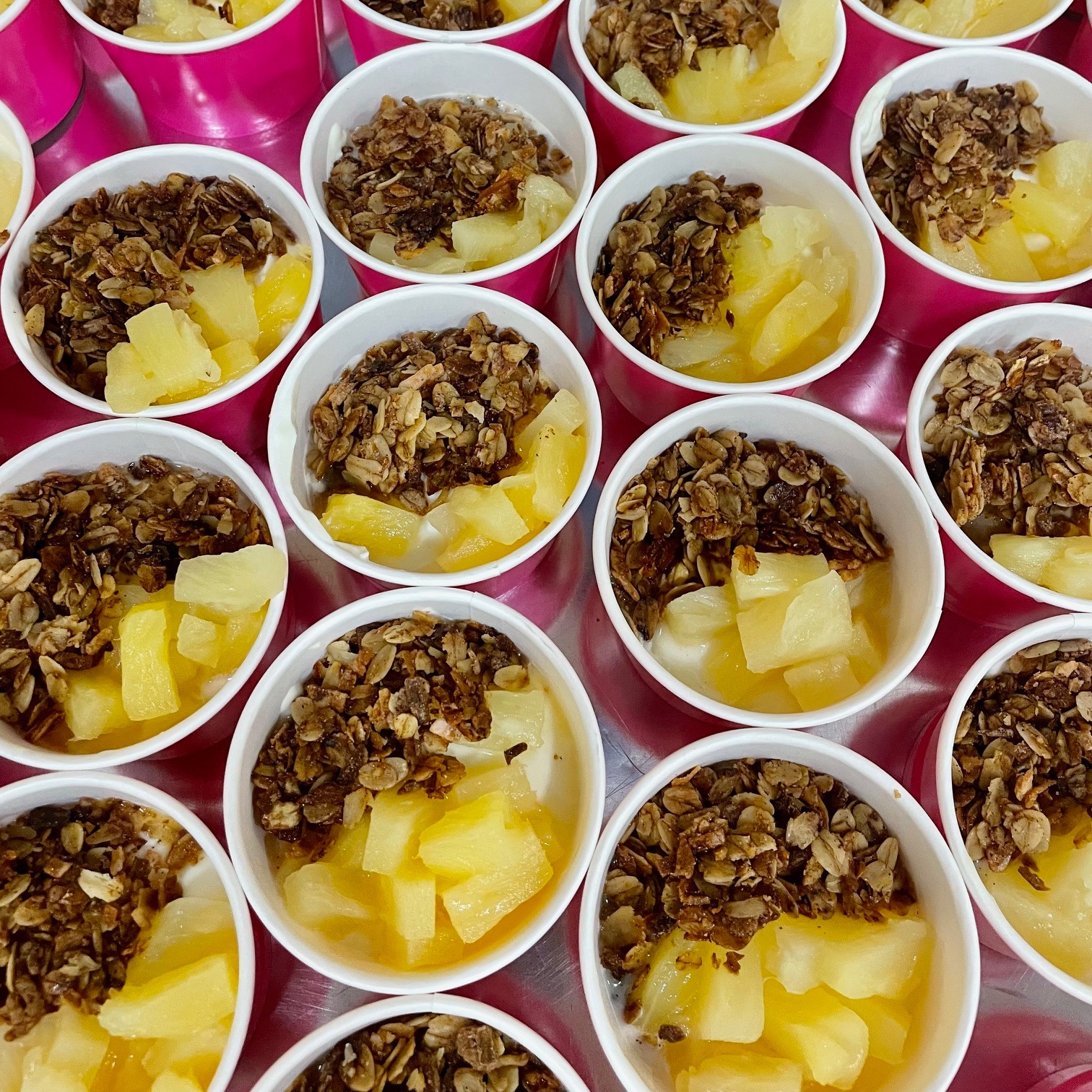 A person wearing gloves is slicing cucumbers on a cutting board, with several whole cucumbers arranged neatly in front of them.