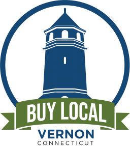A logo featuring a blue lighthouse within a circular border, with the text 'BUY LOCAL' in white and 'VERNON' in green on a ribbon below.