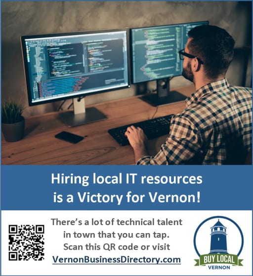 A person sitting at a desk with two computer monitors displaying code, promoting local IT resources in Vernon with a QR code for more information.