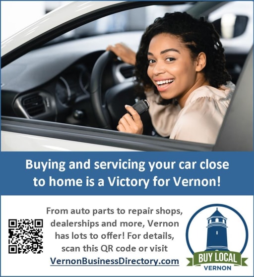 A smiling woman sits in the driver's seat of a car, promoting local car services in Vernon with a message about the benefits of buying and servicing vehicles close to home.
