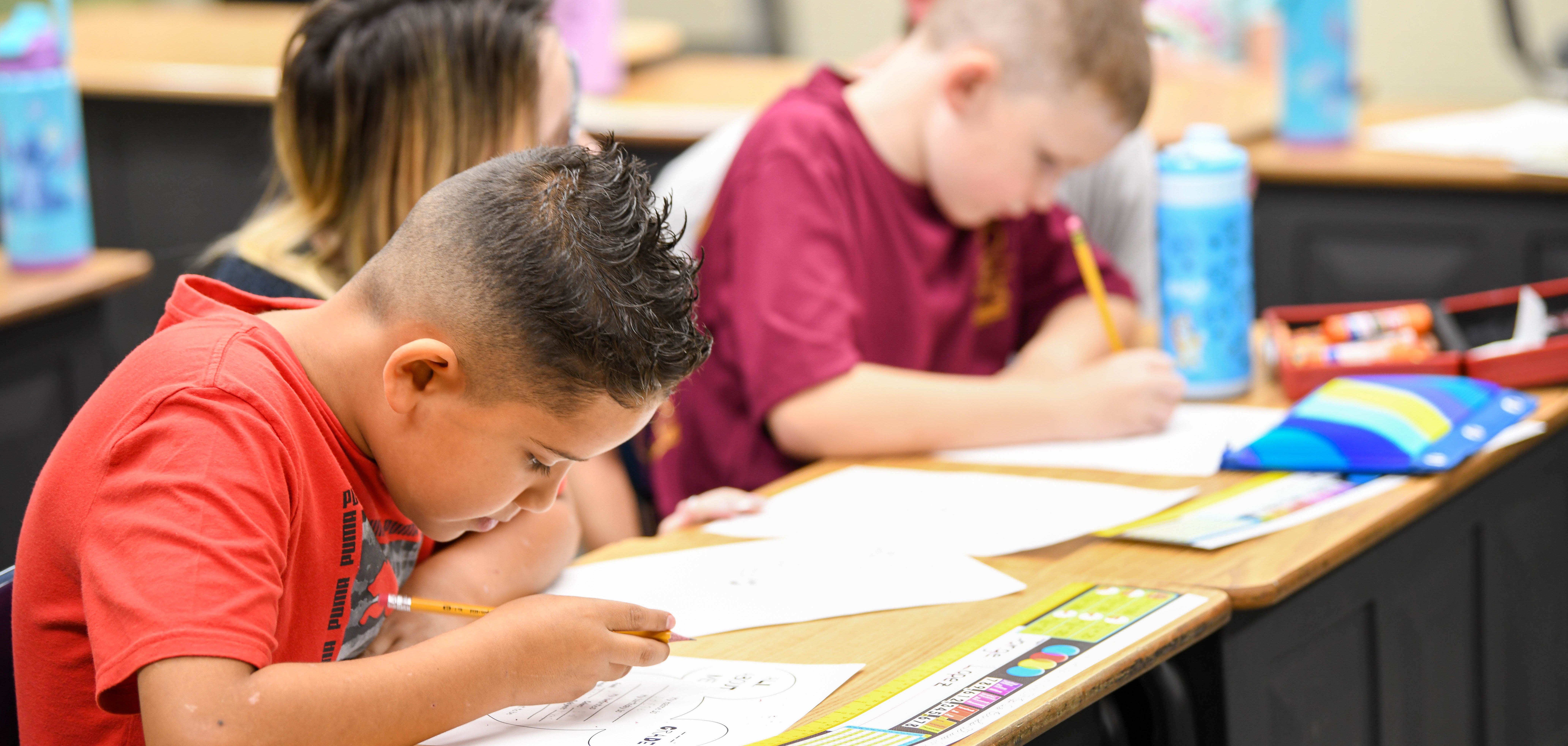 two kidsworking at desks