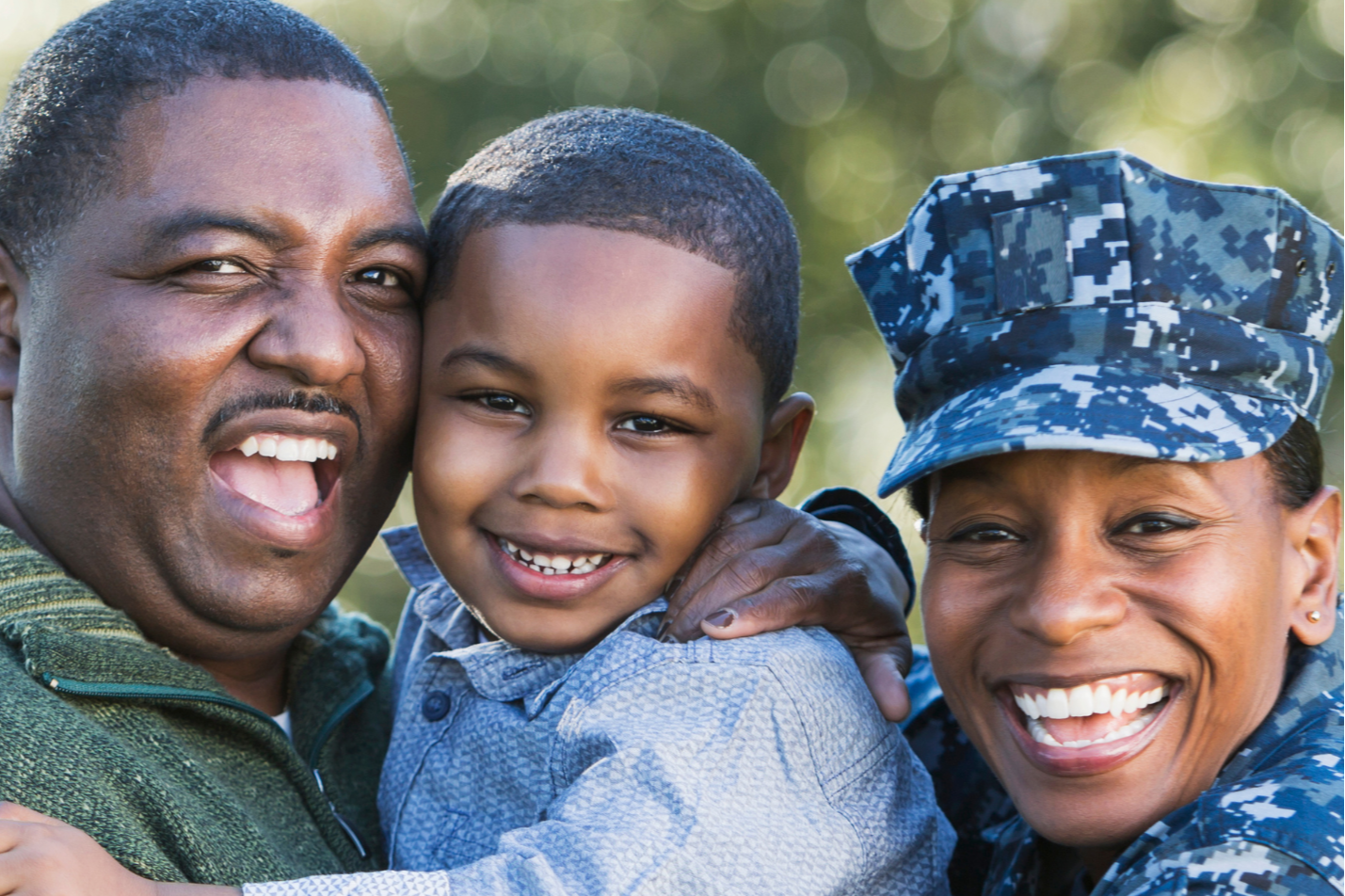 A family portrait featuring a smiling adult man, a smiling boy, and a woman in a military uniform.