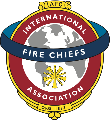 A circular emblem featuring a globe surrounded by a red border with the text 'International Fire Chiefs Association' and a blue ribbon across the globe, displaying a fire service symbol at the bottom.