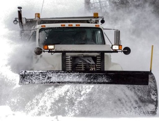 Snow plow removing snow from street