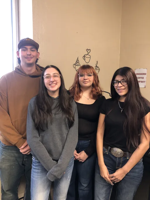 one boy and three girls smiling