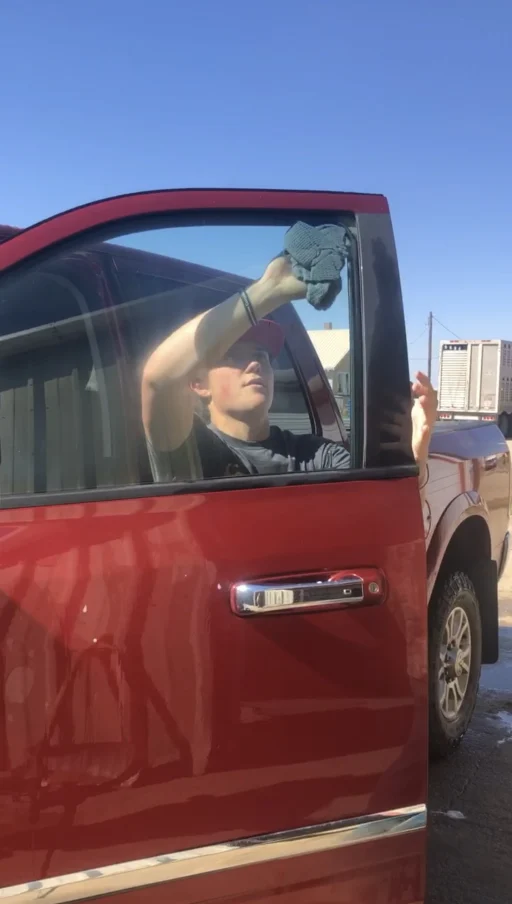 Student cleaning a red truck