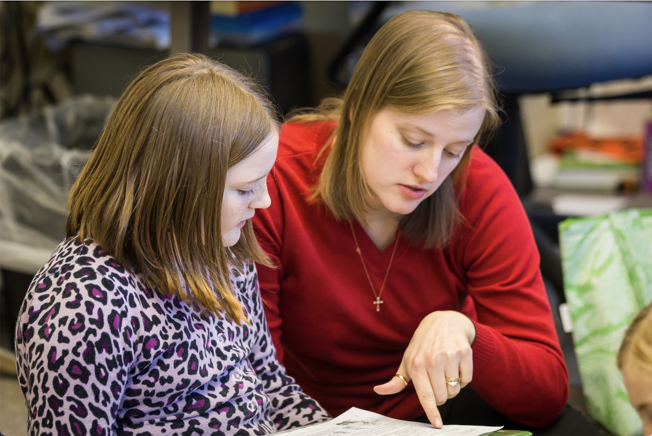 Teacher and student reading a book