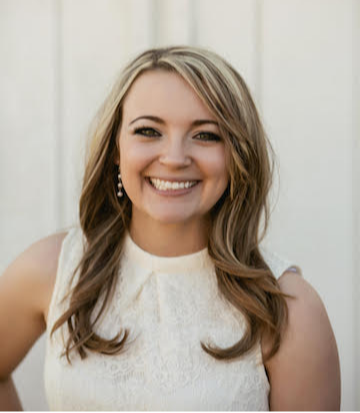 Woman with blond highlights wearing white top smiling