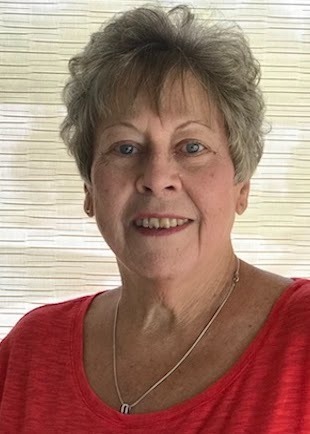 Woman with dark grey har wearing a red top smiling