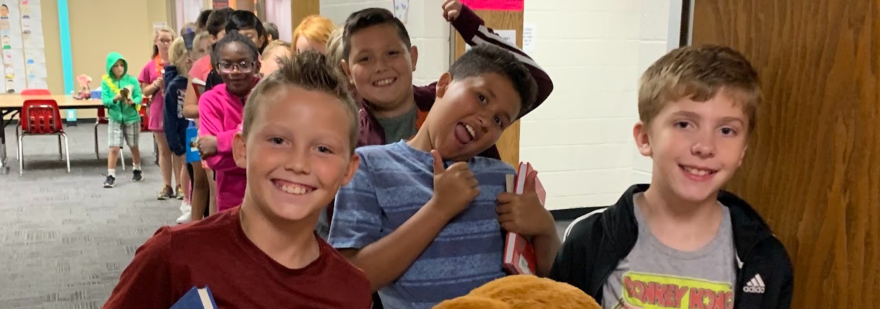 Students smiling in hallway lining up