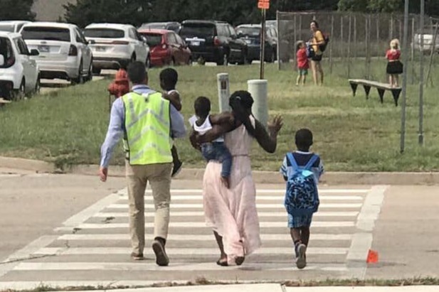 A group of people crossing a street at a crosswalk.