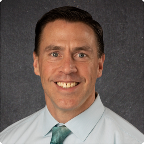 Man smiling with a green shirt and green tie