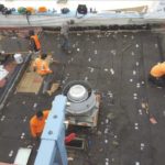 People working on a rooftop construction project.