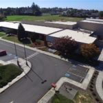 School building with expansive parking lot.