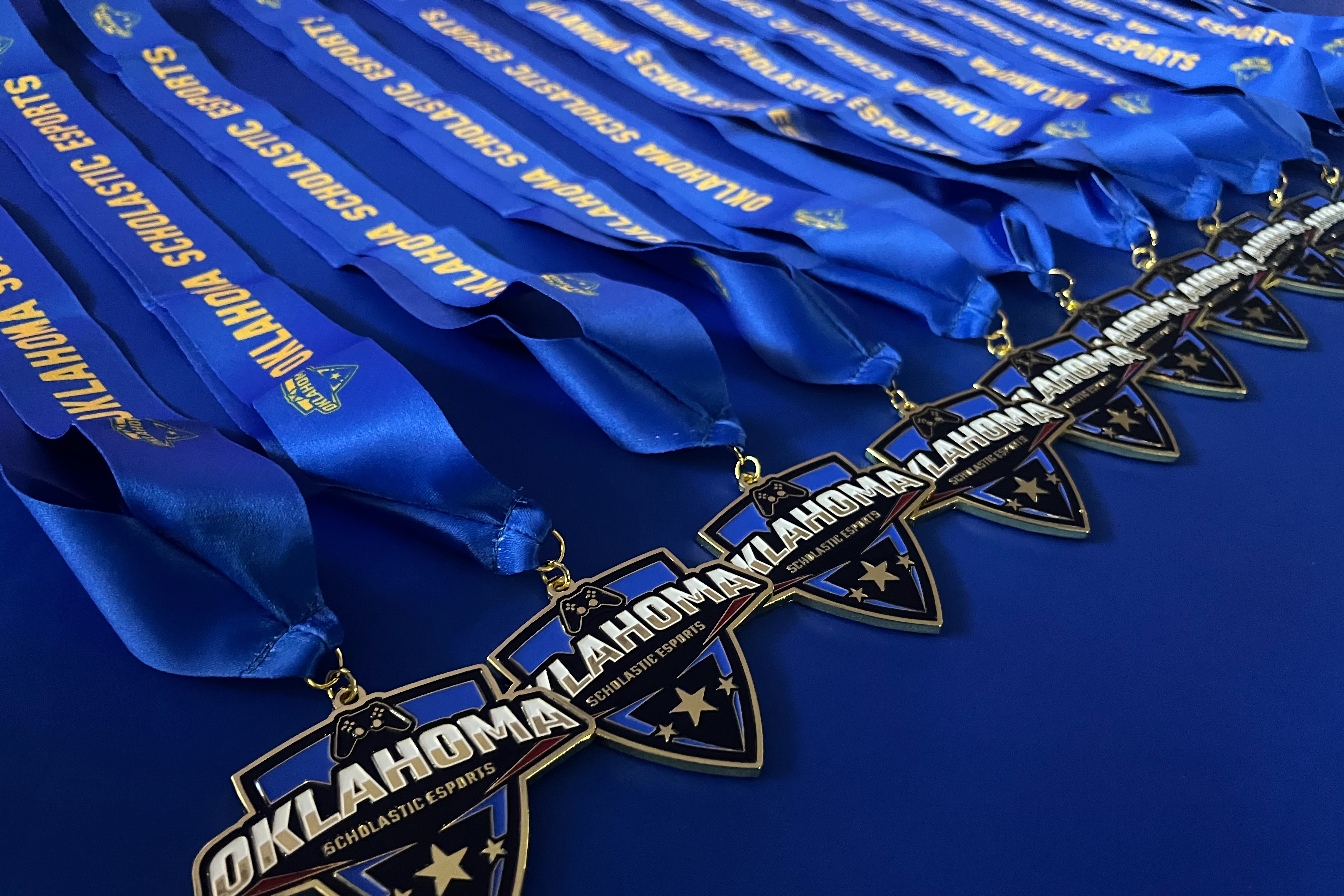 Blue race ribbons and medals with "Oklahoma" and "Landmark" text on them are displayed on a blue background.