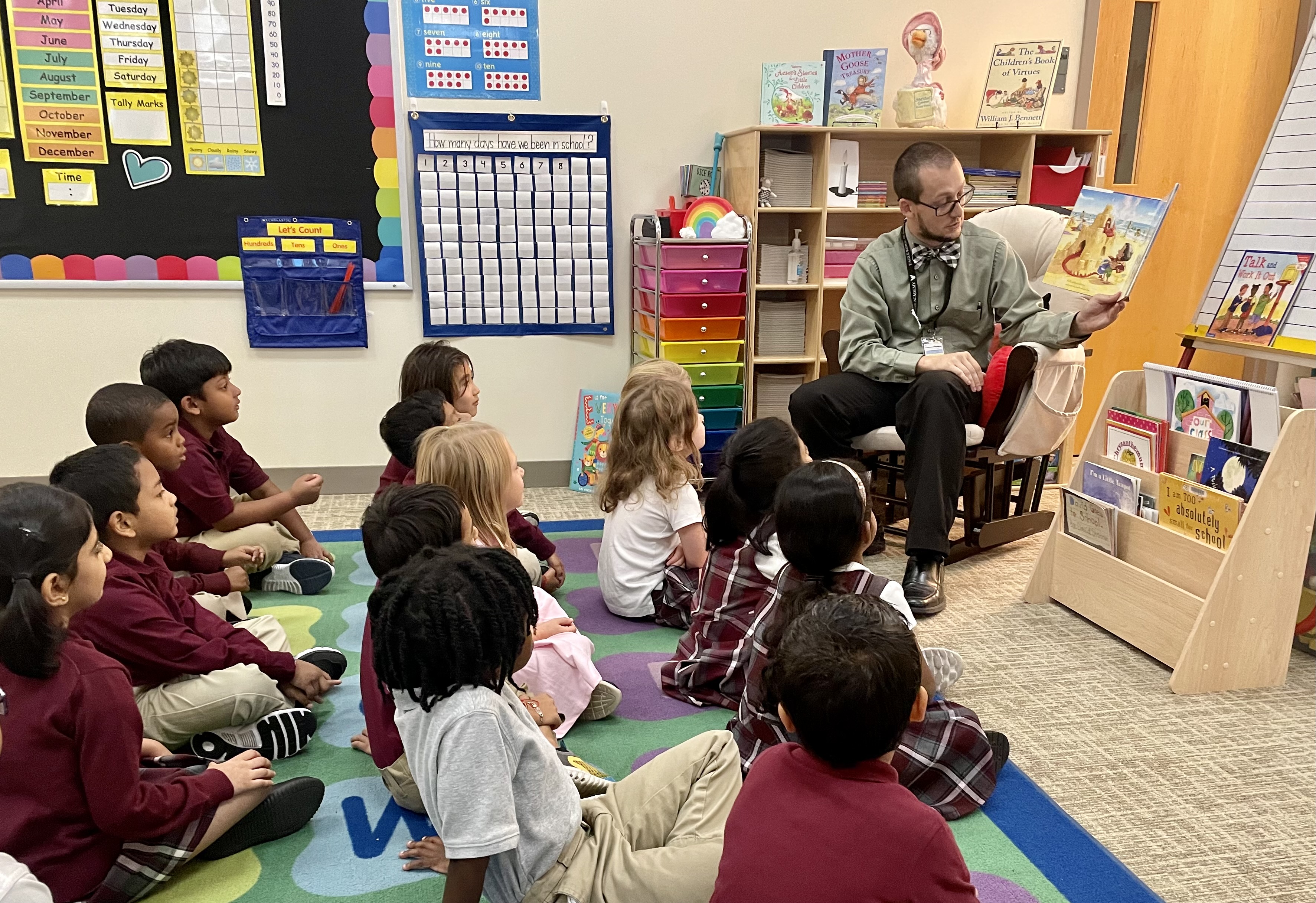 Assistant principal reading to a group of first graders on the floor