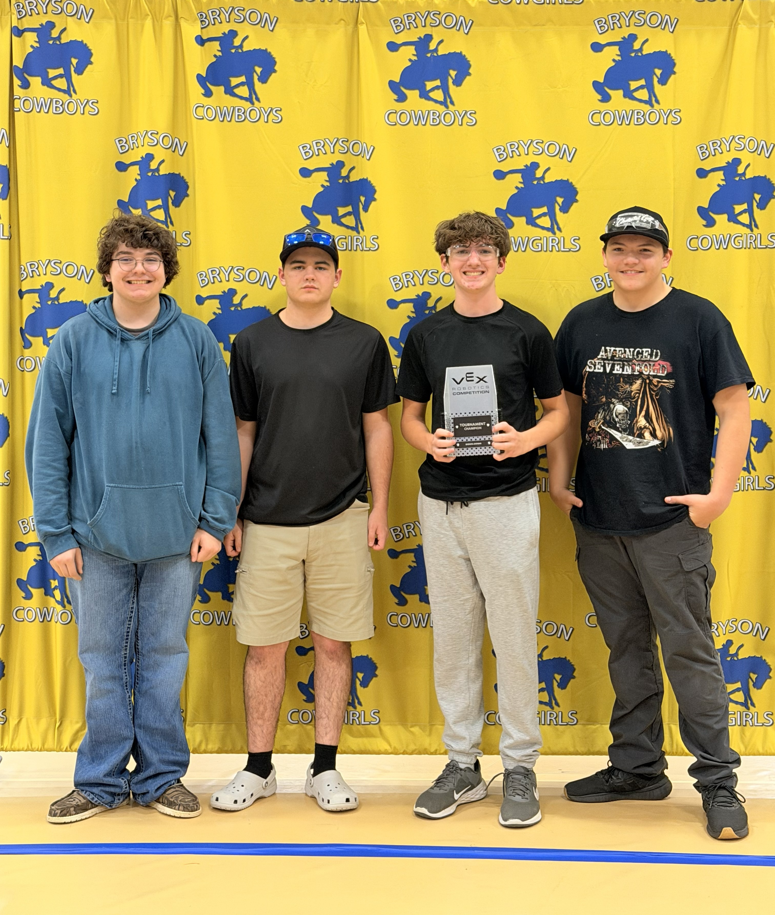 robotics team posing with trophy.