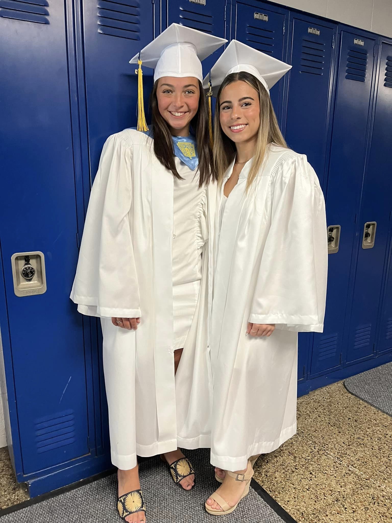 Two girls smiling with graduation gowns