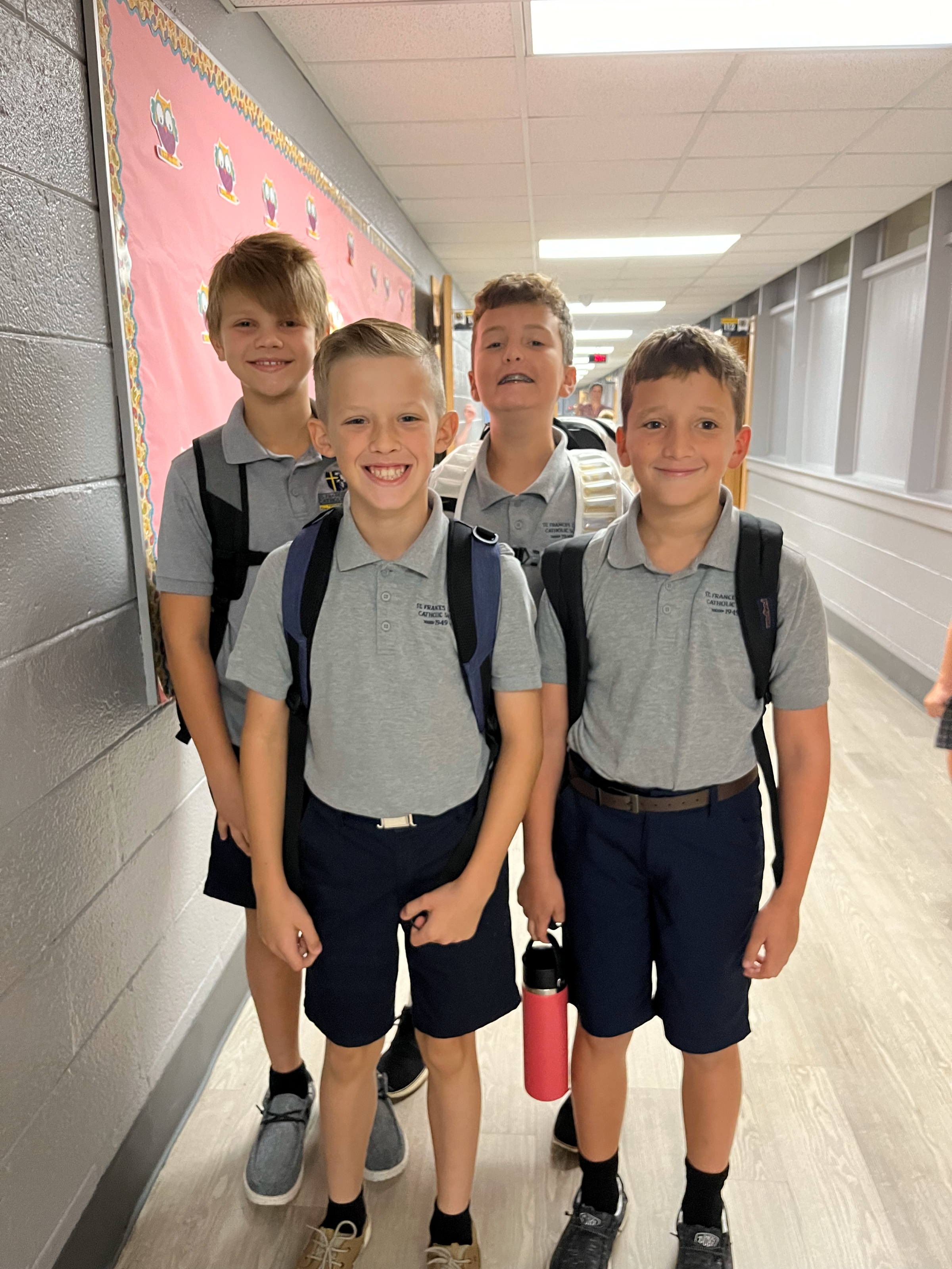 grade school boys smiling in hall way before school