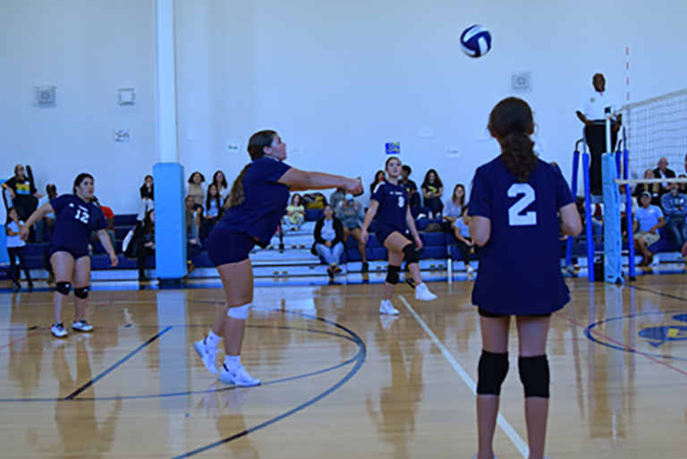 Girls Playiing volleyball  at gym 