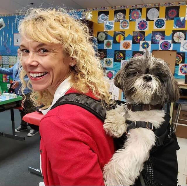 Woman Smiling with a dog in a backpack 