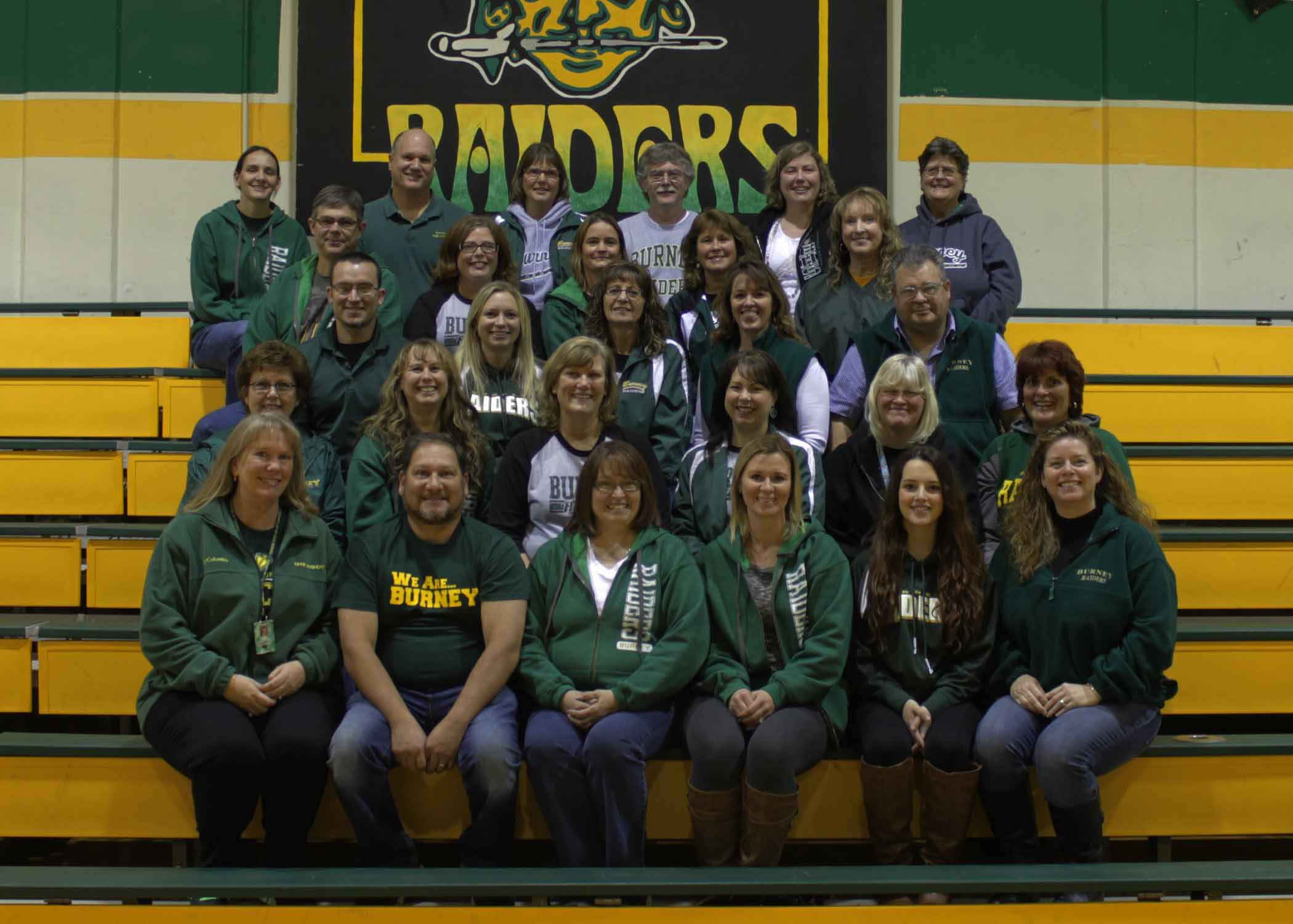 Teachers posing for a photo in a school gym 