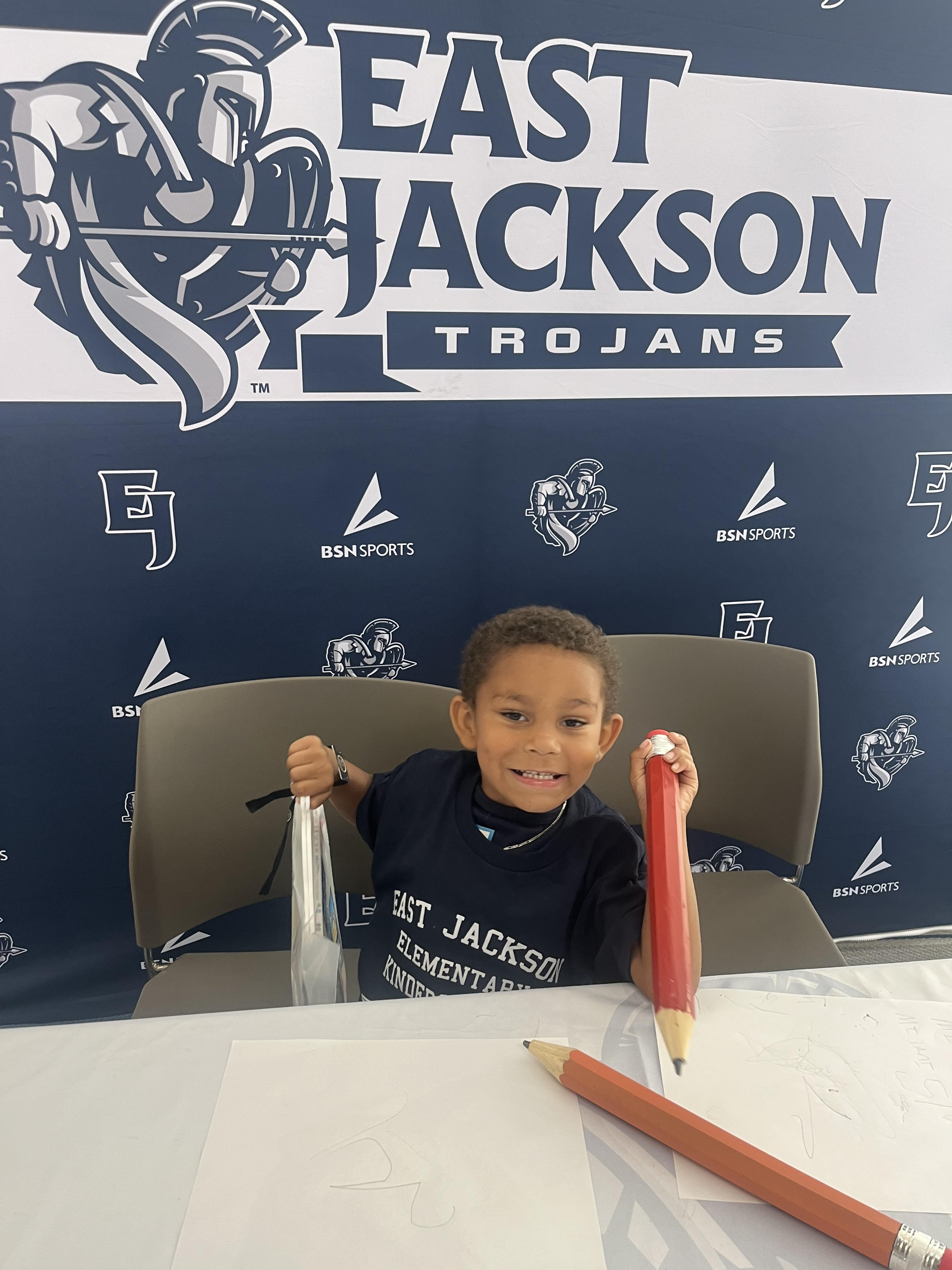 Kindergarten student sitting and smiling