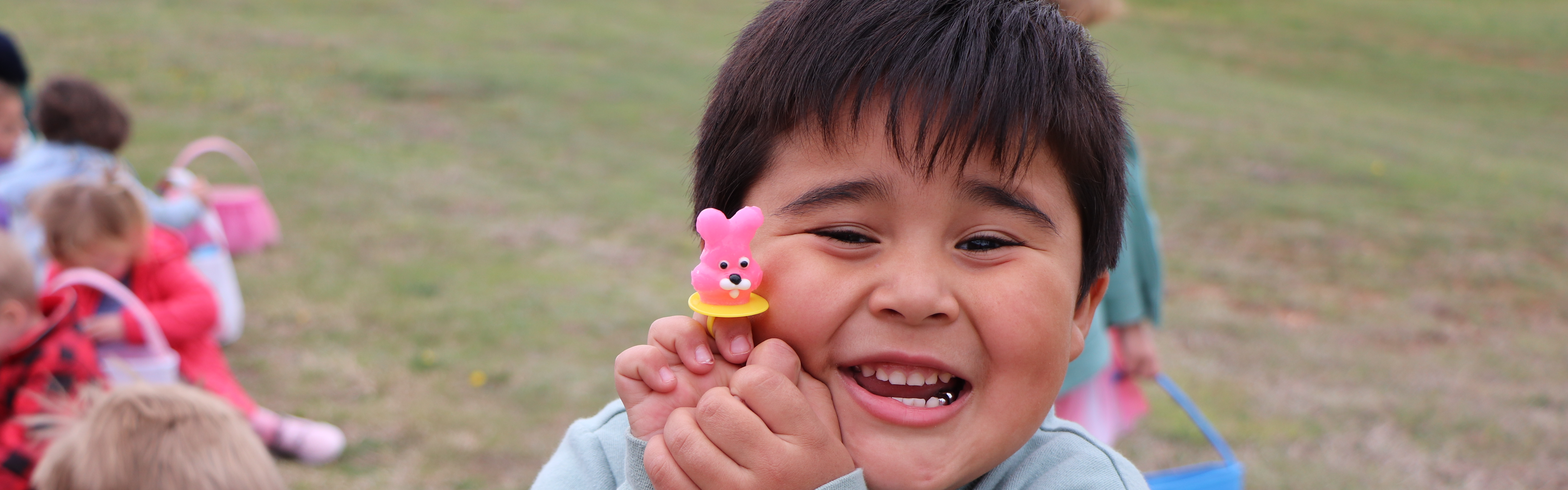 central elementary student smiling holding a toy