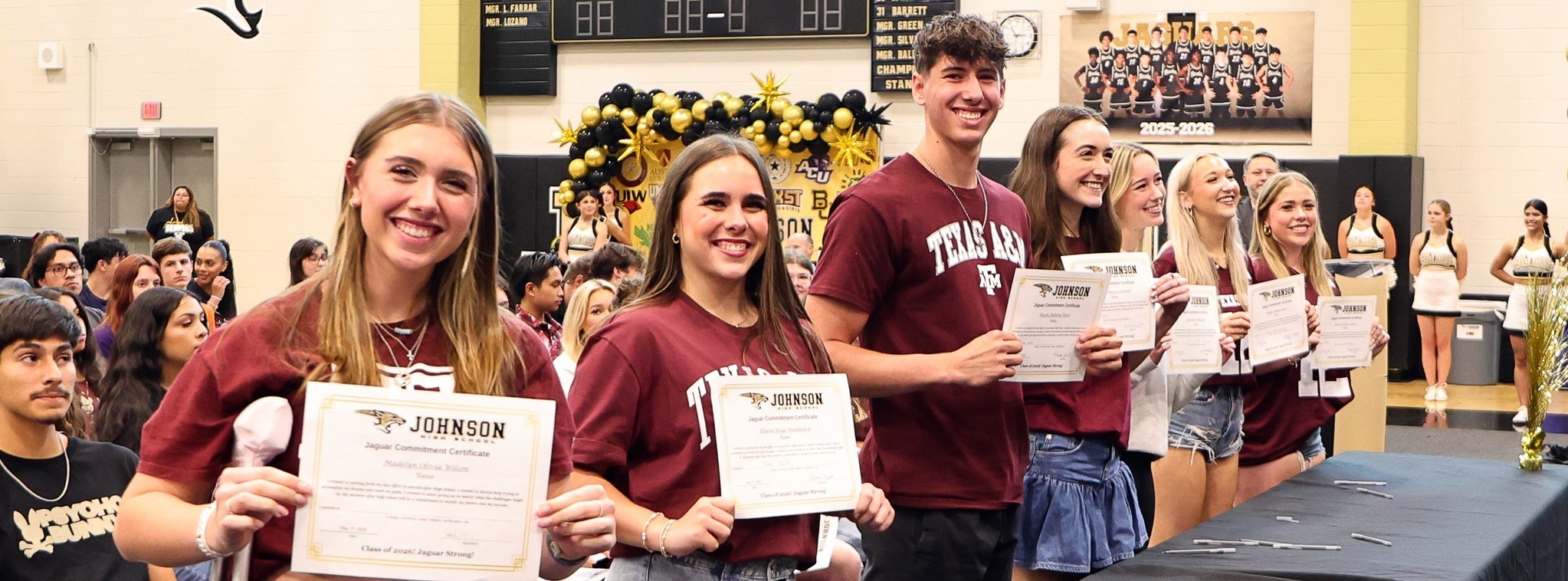 A line of students carrying a certificate for their commitment to succeed after high school.