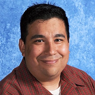 A man with short hair grinning