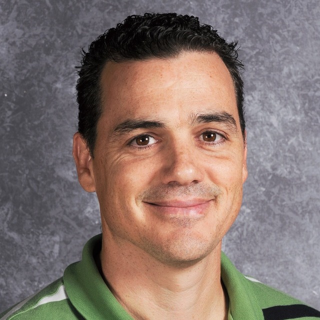 A man with short hair grinning