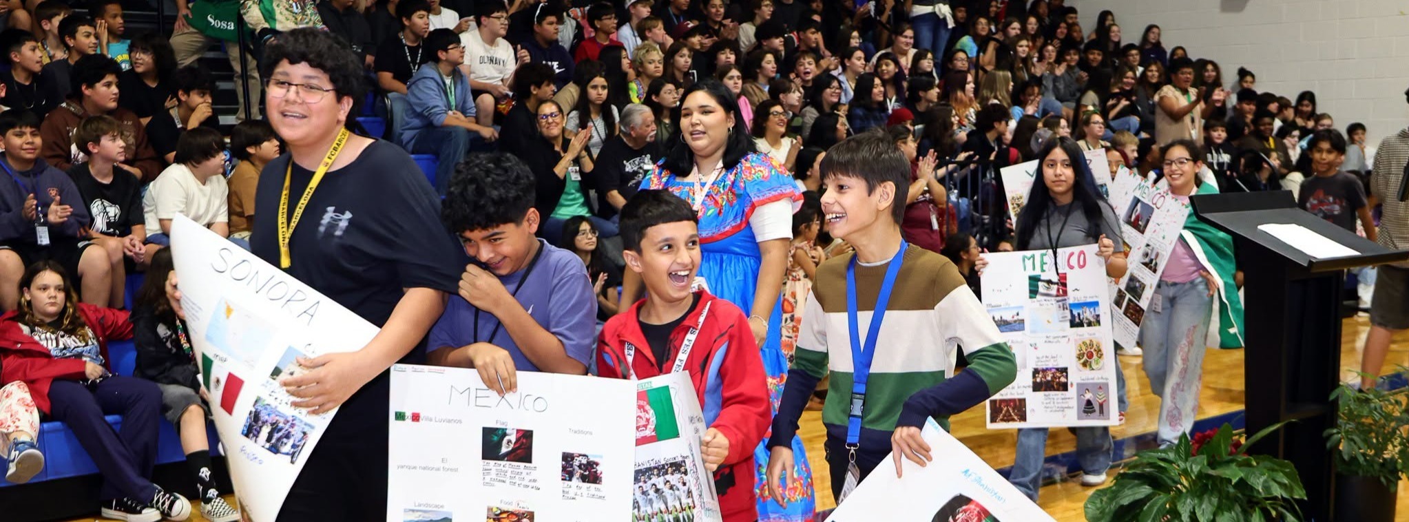 A group of students carrying posters with information about Hispanic countries.
