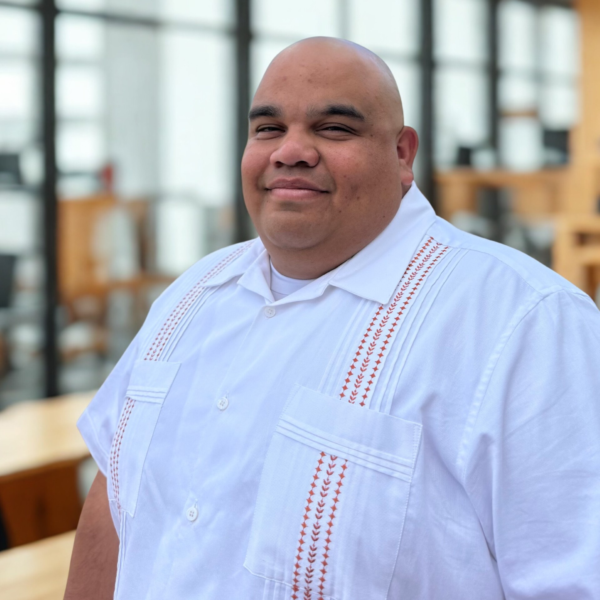 A man wearing a white button up shirt smiling