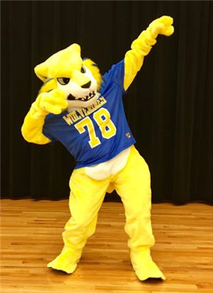 A yellow mascot character wearing a blue jersey with the number 78 strikes a playful pose on a wooden floor, set against a dark backdrop.