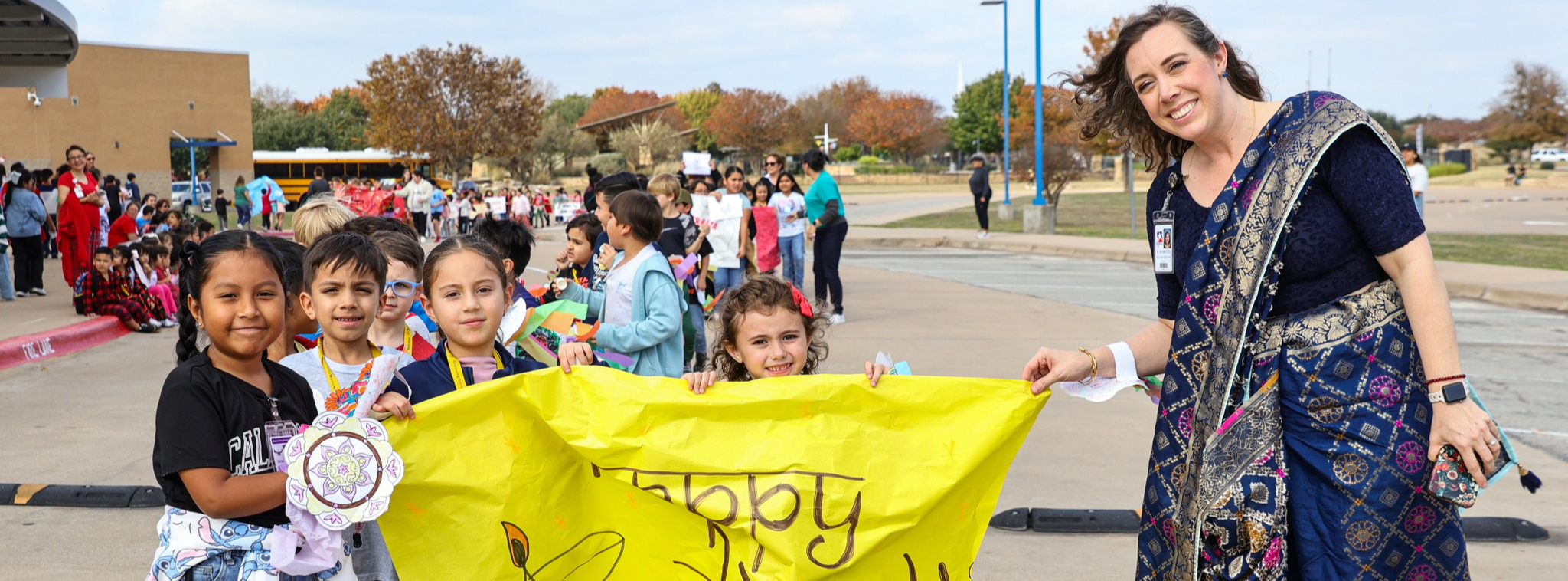 A group of students carrying a banner alongside their teacher