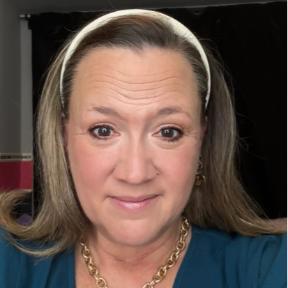 A grinning woman with long hair posing for a selfie.