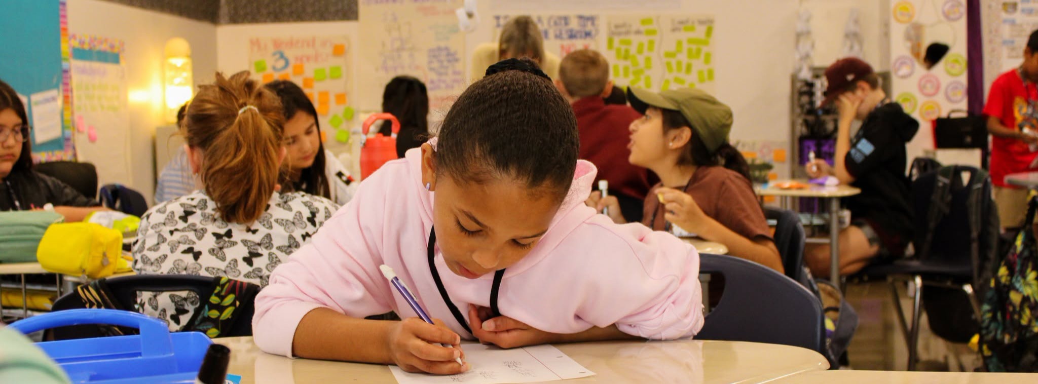 A student in a classroom with students working on a class assignment.