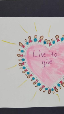 A colorful drawing featuring a large pink heart surrounded by small figures and the phrase 'Live to give' written in the center.