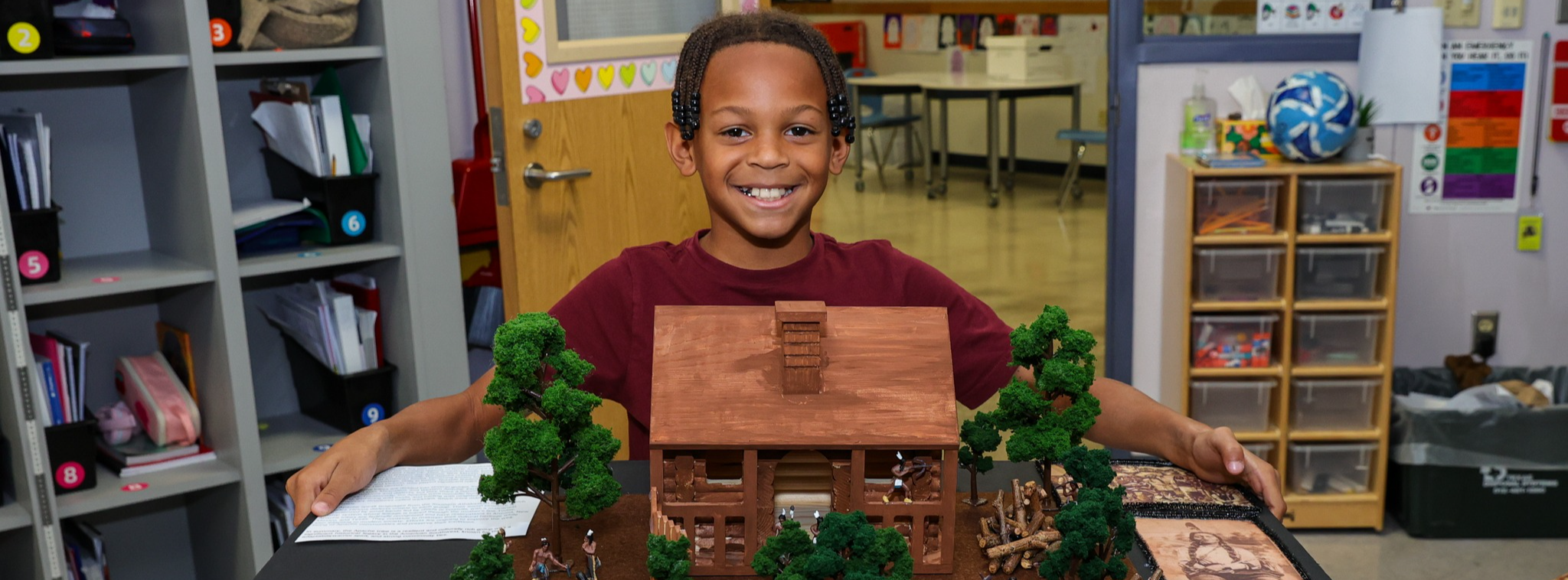 A student carrying a diorama